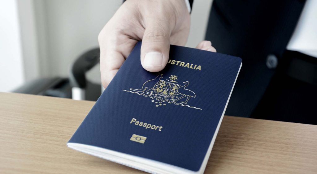 A person handing over their passport for checking at immigration.