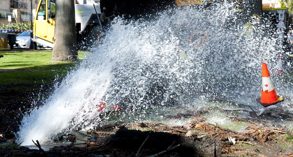 Water gushing from burst water pipe.