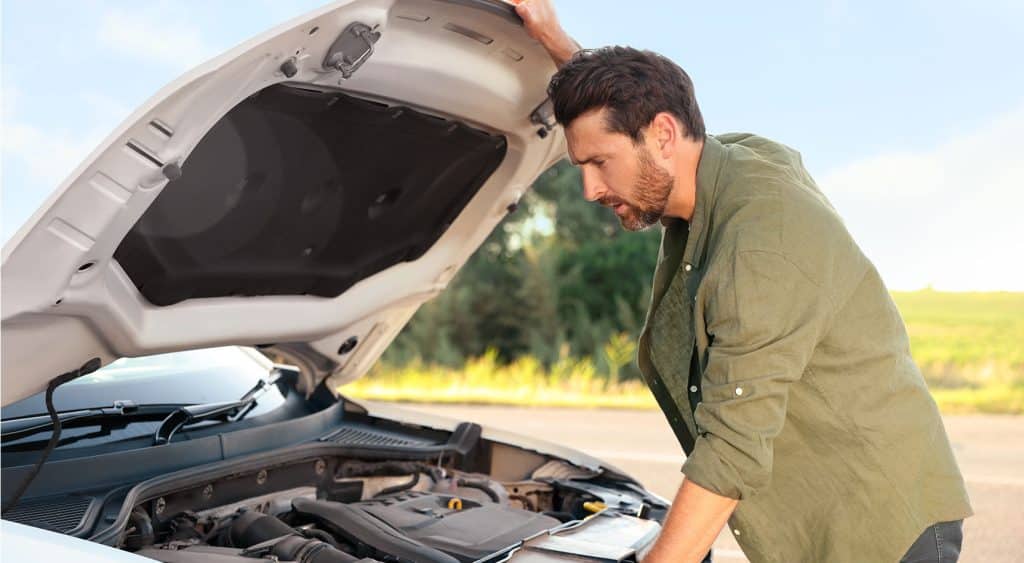 A man looking under his bonnet.