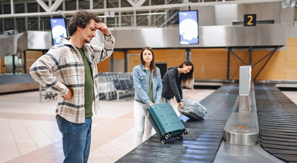 Man waiting at luggage carousel missing baggage.