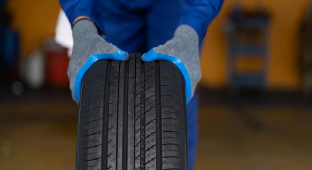 Mechanic holding tyre.