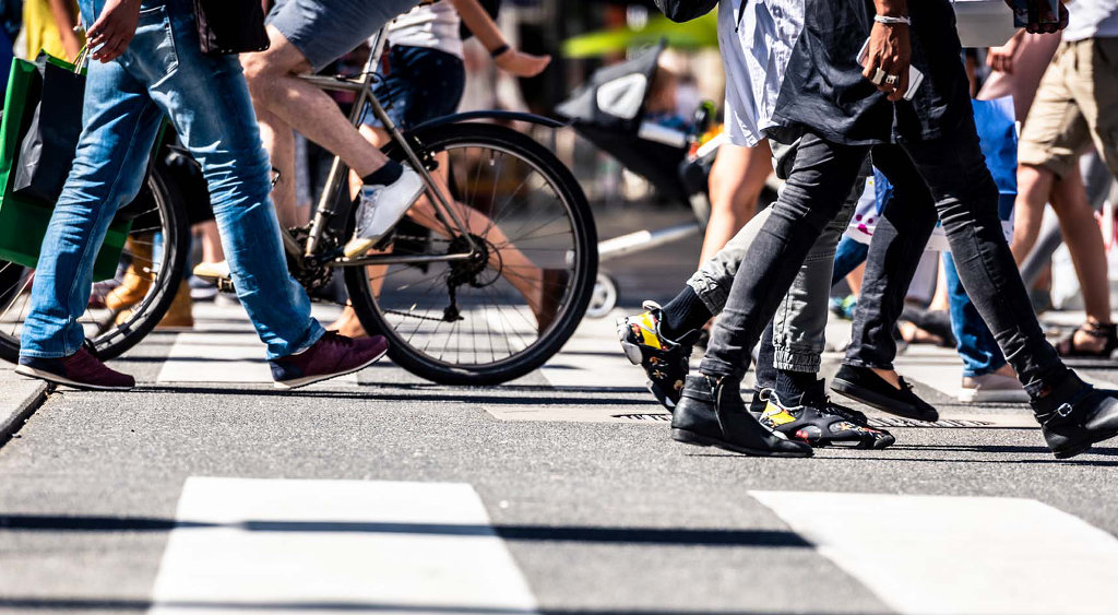 People walking across a pedestrian crossing.