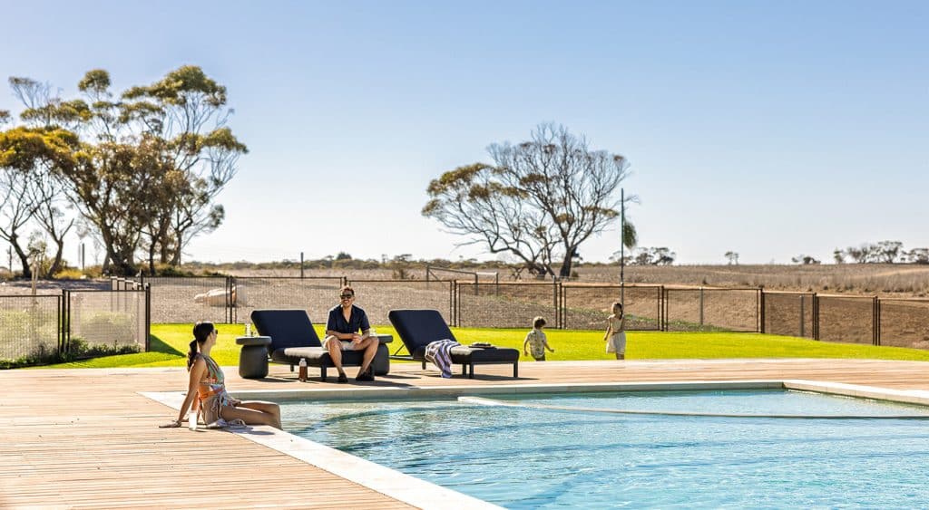 A family lounges by the pool within the Monarto Safari Resort.