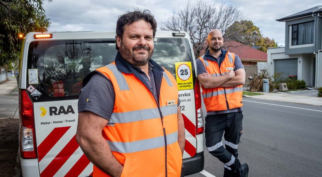 RAA Patrols Gary Dewing and  Adam Strugala standing behind an RAA van on the road.