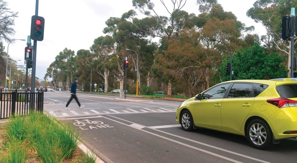 Picture of a man crossing at a raised pedestrian actuated crossing in Hutt Road, Adelaide