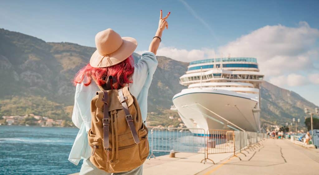 Tourist waving to a cruise ship.