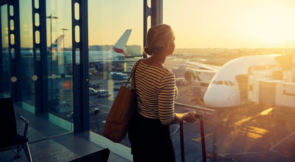Person looking out airport window.