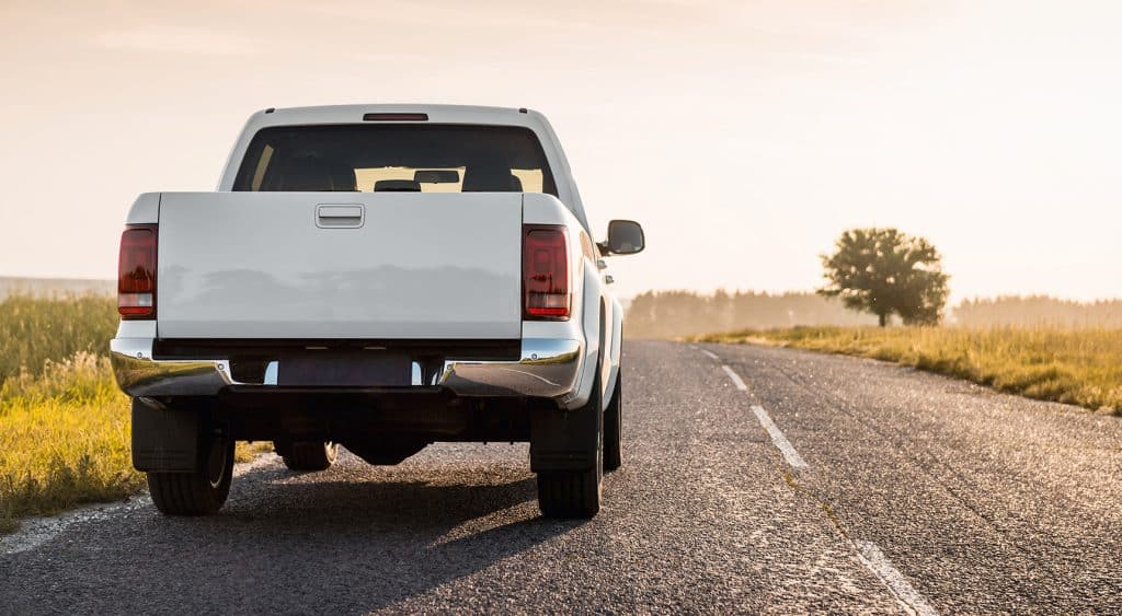 A white pick-up truck parked on a road in rural Australia