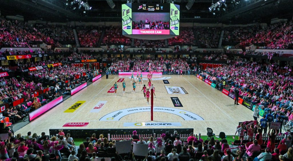 Adelaide Thunderbird netball players on court in a packed stadium