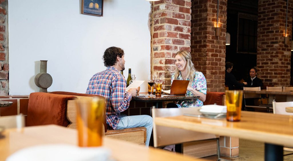 A couple sitting eating at restaurant.