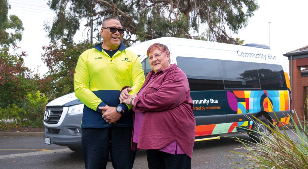 Volunteer driver Eric Schwenke and regular passenger Jeanette Moody stand in front of the City of Onkaparinga community bus