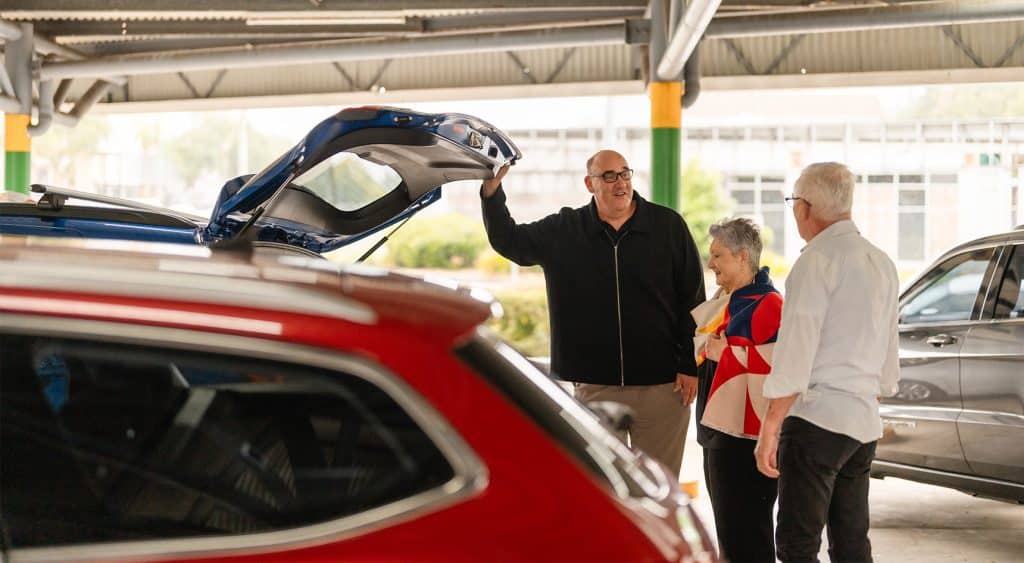 A couple talking to a car salesperson and buying a new car
