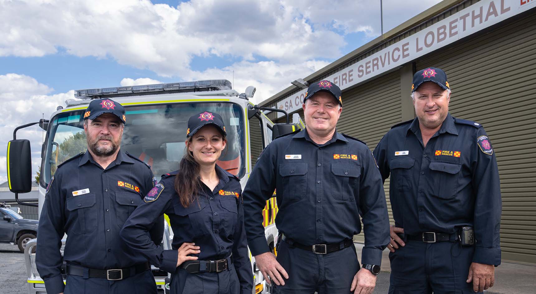 Lobethal CFS Brigade in front of a fire truck and the fire station.
