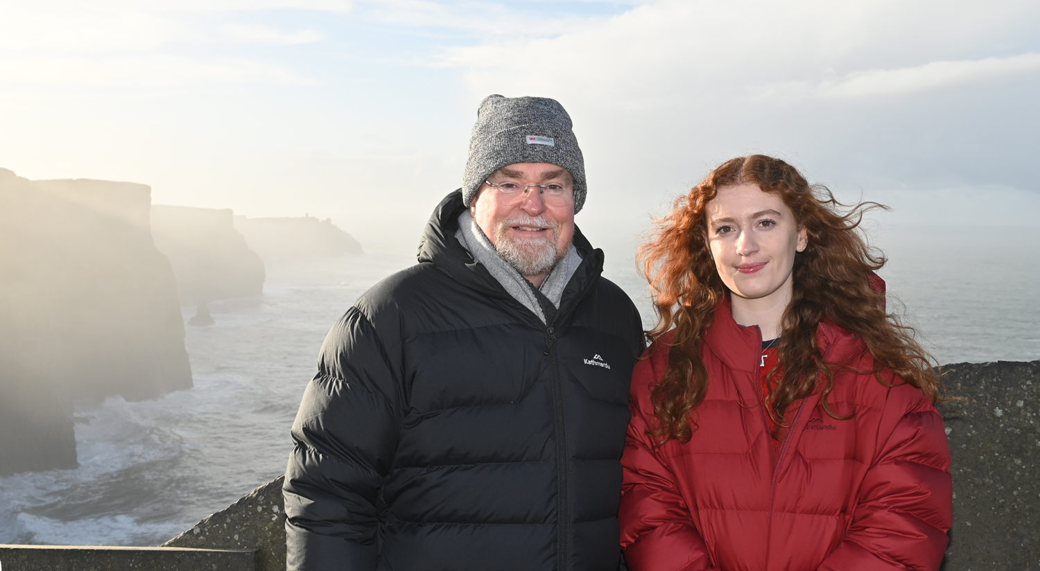 Father and daughter out in front of scenic cliffs