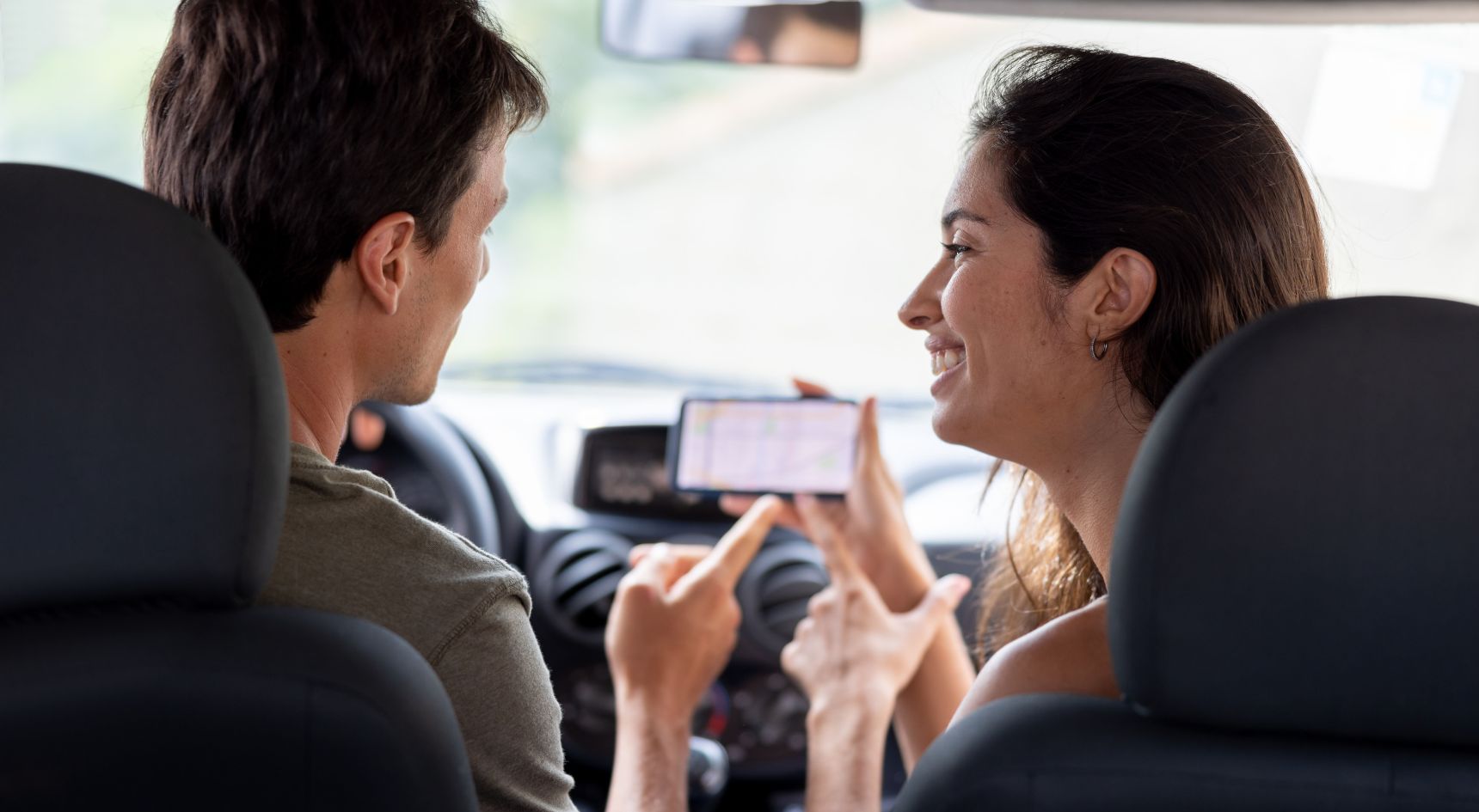 Passenger showing driver her phone.