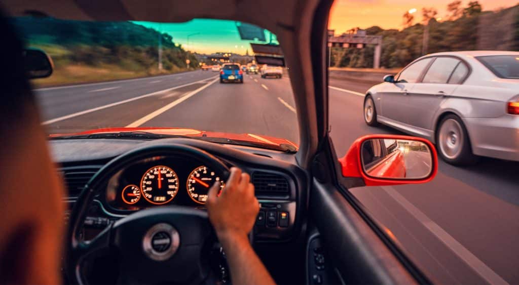 Person driving on a highway with cars ahead and to the right side.
