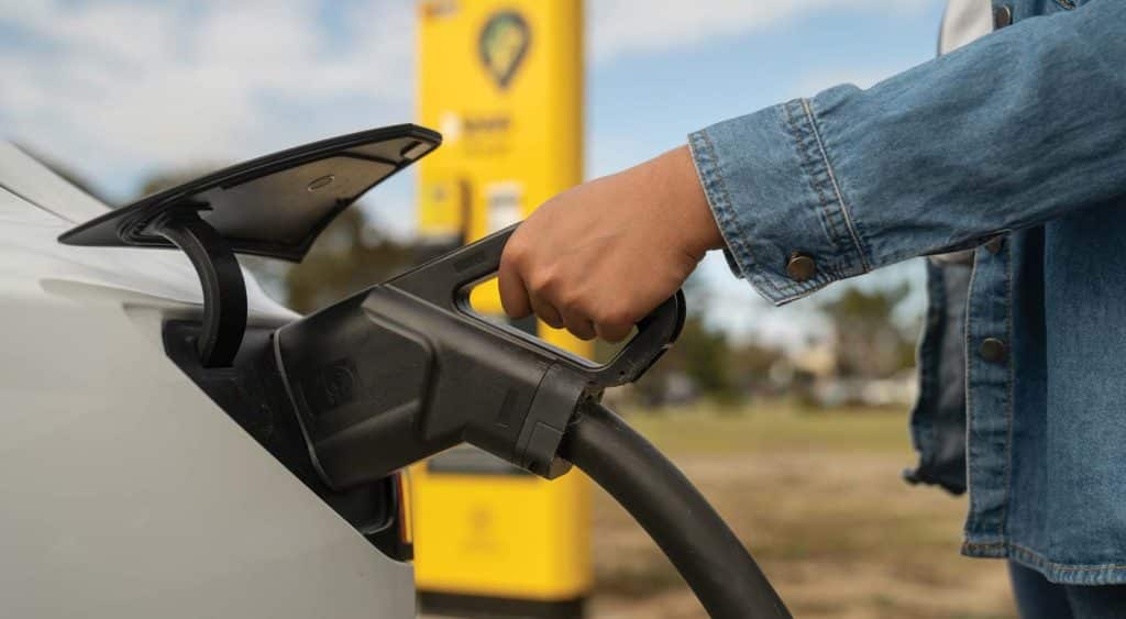 A person charging an EV.